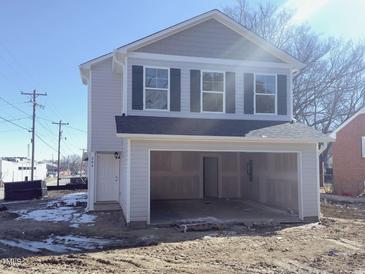 Two-story home featuring an attached garage, light-colored siding, and dark shutters and roofing at 204 S Beaumont Ave, Burlington, NC 27217