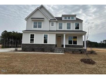 Charming two-story home with a stone-accented facade and inviting covered porch at 266 Weddington Way, Benson, NC 27504