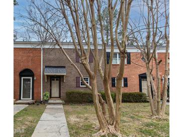 Brick townhouse exterior with landscaping and walkway at 6409 New Market Way, Raleigh, NC 27615
