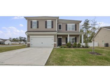 Two-story house with gray siding, white garage door, and landscaped lawn at 148 Cumberland Dr, Sanford, NC 27332