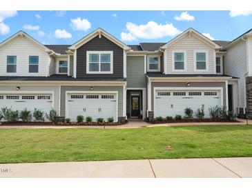 Two-story townhome with gray and white exterior, two-car garage, and landscaping at 116 Kobus Ct, Garner, NC 27529