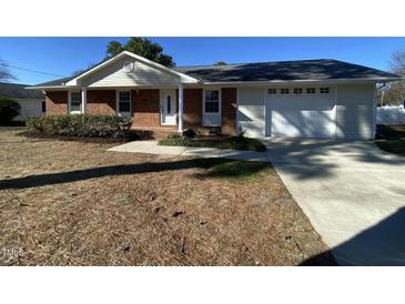 Brick ranch home with attached garage and well-maintained lawn at 307 Westfield Dr, Dunn, NC 28334