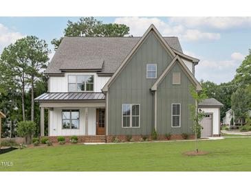 Two-story home featuring mixed siding, a covered porch, and professionally landscaped yard at 3400 Amelia Grace Dr # 46, Fuquay Varina, NC 27526