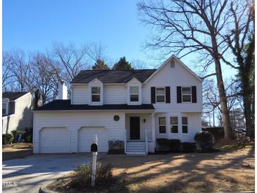 Charming white two-story home with a two-car garage and well-maintained front yard on a sunny day at 4300 Hickory Ridge Dr, Raleigh, NC 27609
