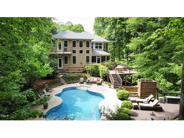 Relaxing pool area with a kidney-shaped pool, outdoor seating, and mature landscaping at 5240 Indigo Moon Way, Raleigh, NC 27613