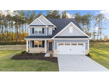 Two-story house with gray siding, white garage door, and landscaping at 529 Ravensworth Dr, Garner, NC 27529