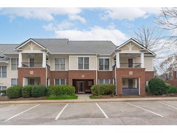 Beautiful condo with brick accents and a covered balcony, creating a charming and inviting facade at 105 Fountain Ridge Pl, Holly Springs, NC 27540