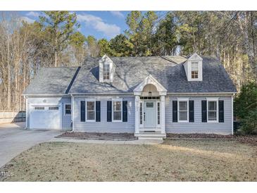 Gray house with attached garage and manicured lawn at 1702 Grand Barton Ct, Apex, NC 27502