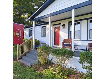 Inviting front porch with wicker seating and freshly painted white brick exterior at 3259 Us 421, Lillington, NC 27546