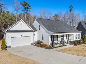 Charming white home with a two-car garage, covered porch, and manicured lawn at 430 Heart Pine Dr, Wendell, NC 27591