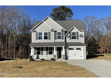 Two-story house with gray siding, two-car garage, and a landscaped yard at 171 Wynd Crest Way, Benson, NC 27504