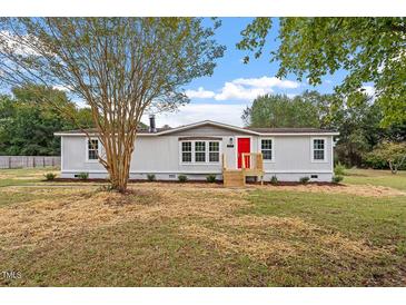 Newly renovated mobile home with gray siding and red door, situated on a spacious lot at 262 Homestead Dr, Selma, NC 27576