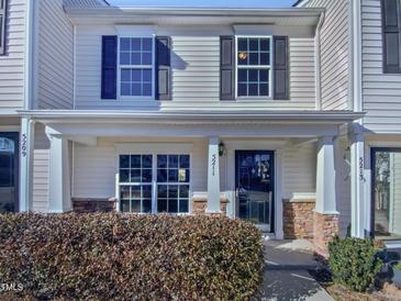 Beige two-story townhome with a covered porch and landscaping at 5211 Blue Lagoon Ln, Raleigh, NC 27610