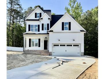 New construction two-story home featuring white siding, black shutters, and a two-car garage with a paved driveway at 2628 Silver Gate Ct, Wake Forest, NC 27587