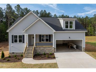 Charming single-Gathering home featuring stone accents, gray siding, attached garage, and a welcoming front porch at 95 Purslane Dr, Franklinton, NC 27525