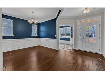Spacious dining room features hardwood floors, elegant chandelier, and wainscoting details at 664 Long Melford Dr, Rolesville, NC 27571