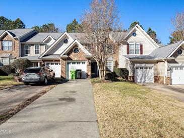 Charming townhome featuring a well-manicured lawn, attached garage, and inviting curb appeal in a desirable neighborhood at 9412 Harvest Acres Ct, Raleigh, NC 27617
