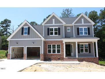 Charming two-story home with a two-car garage, brick accents, and a covered front porch at 1021 Smoke Willow Way # 130, Rolesville, NC 27571