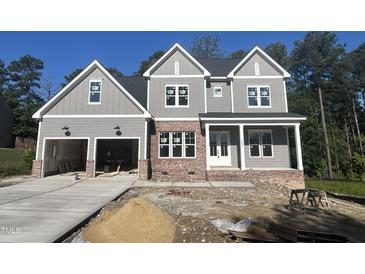 New construction two-story home featuring a brick base, neutral siding, three gables, and an attached two-car garage at 1021 Smoke Willow Way # 130, Rolesville, NC 27571