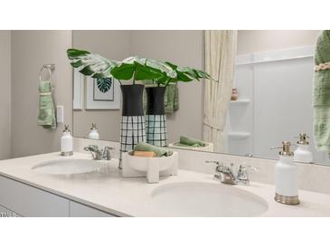 Double vanity bathroom with modern fixtures and a large mirror at 104 Kobus Ct, Garner, NC 27529