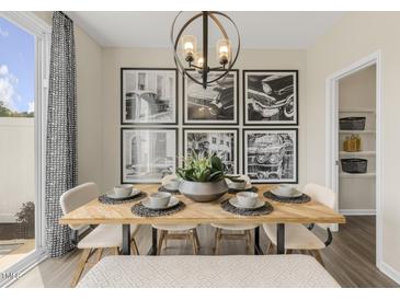 Bright dining room features a wood table, six chairs, and a large gallery wall at 120 Kobus Ct, Garner, NC 27529