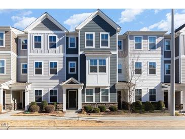 Three-story townhouses with gray siding, stone accents, and landscaping at 5940 Illuminate Ave, Raleigh, NC 27616