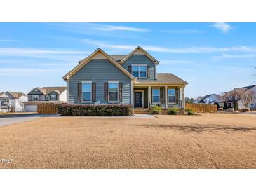 Charming two-story home featuring a welcoming front porch and well-maintained landscaping at 8217 Cannon Grove Dr, Willow Springs, NC 27592