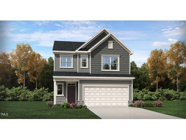 Two-story home with gray siding, white garage door, and landscaping at 1139 Atterlee Ln, Graham, NC 27253
