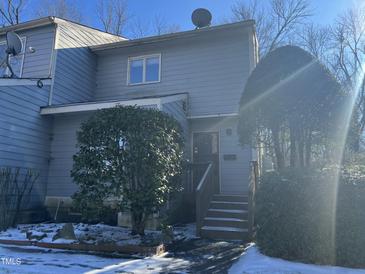 Exterior view of a light gray townhouse with steps leading to the entrance and landscaping at 250 S Estes Dr # Apt 94, Chapel Hill, NC 27514