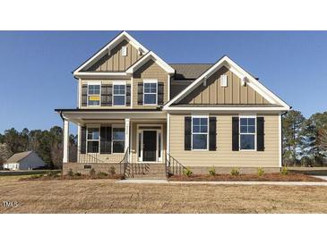 Two-story house with beige siding, black shutters, and a front porch at 181 Sage Ln, Four Oaks, NC 27524