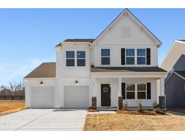 Two-story white farmhouse with black accents, two-car garage, and landscaping at 35 Mable Court # 3, Lillington, NC 27546