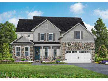 Two-story home with gray shake siding, stone accents, and a three-car garage at 4820 Bristol Meadow Dr, Raleigh, NC 27603