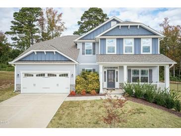 Two-story house with gray siding, stone accents, and a two-car garage at 55 Watermelon Dr, Franklinton, NC 27525