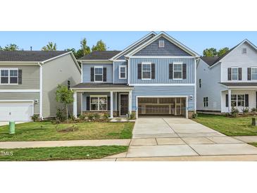 Two-story home with blue siding, two-car garage, and landscaped lawn at 1013 Aspen View Dr, Raleigh, NC 27610