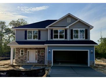 Two-story home featuring stone accents, a two car garage and black shutters on the windows at 203 Lake Edge Dr, Lillington, NC 27546