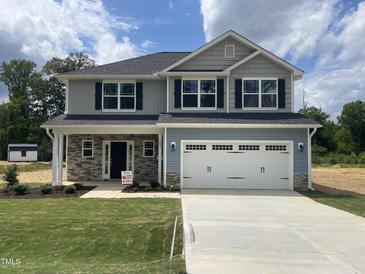 Charming two-story home with gray and blue siding, black shutters, and a two-car garage at 203 Lake Edge Dr, Lillington, NC 27546