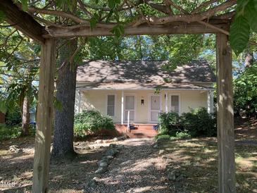 Charming yellow cottage with a front porch and well-maintained landscaping at 322 Mccauley St, Chapel Hill, NC 27516