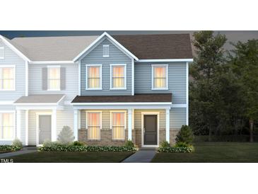 Two-story townhome with light blue siding, brick accents, and landscaping at 371 Fosterton Cottage Way, Raleigh, NC 27603
