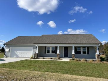 Newly constructed one-story home with gray siding, attached garage, and front porch at 57 Shiloh Dr, Lillington, NC 27546