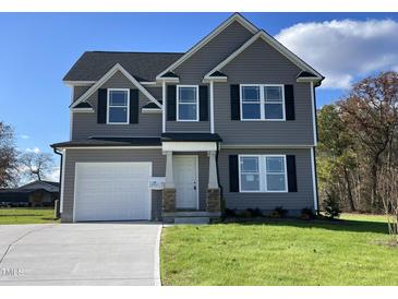 Two-story house with gray siding, white garage door, and landscaping at 59 Holly Grove Ln, Lillington, NC 27546