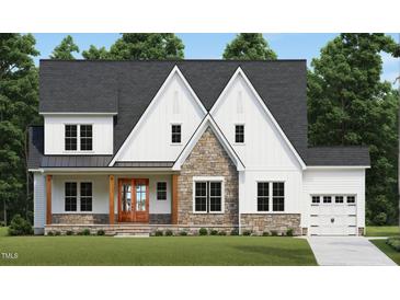 Two-story farmhouse with stone accents, wood front door, and a two-car garage at 1116 Delilia Ln, Wake Forest, NC 27587