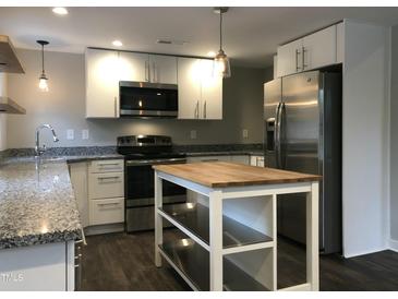 Modern kitchen with stainless steel appliances, granite counters, and a functional center island at 1312 Fay St, Durham, NC 27701