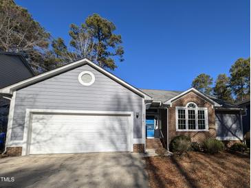 Gray sided house with white garage door and brick accents at 2106 Pathway Dr, Chapel Hill, NC 27516