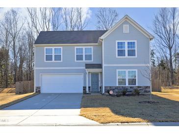Two-story house with gray siding, a white garage door, and a landscaped yard at 601 Joe Gibson Dr, Gibsonville, NC 27249