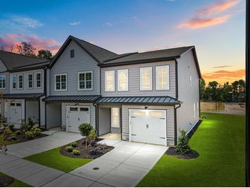 Charming new construction townhome boasts a one-car garage and beautiful gray siding at 712 Jamescroft Way # 26, Rolesville, NC 27571