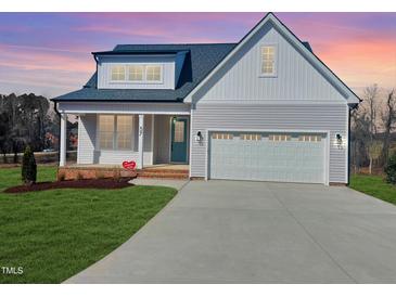 Charming two-story home with a well-manicured lawn and a two-car garage at 57 Nottoway Ln, Wendell, NC 27591