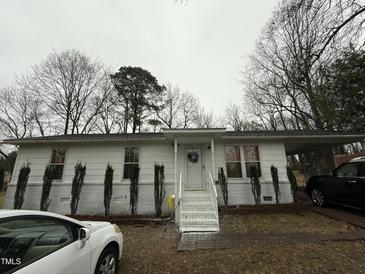 White ranch house with steps, landscaping, and parked cars at 6908 Park Pl, Raleigh, NC 27616