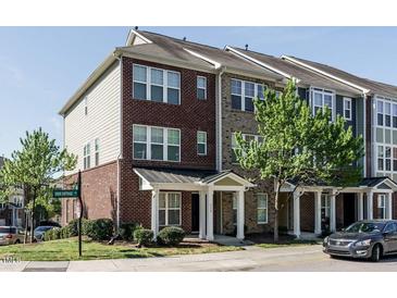 Brick townhome with a front porch and landscaping at 332 Dove Cottage Ln, Cary, NC 27519