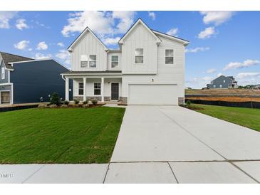 Two-story white farmhouse-style home with a large front yard and driveway at 517 Marthas View Way, Wake Forest, NC 27587