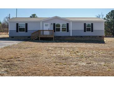 Single-wide manufactured home with gray siding, wood deck, and landscaping at 6545 Old Jefferson Davis Hwy, Cameron, NC 28326